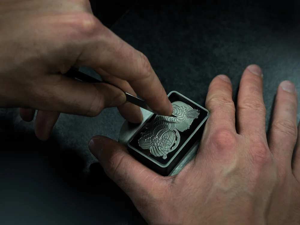 Goldsmith engraving a precious-metal die by hand